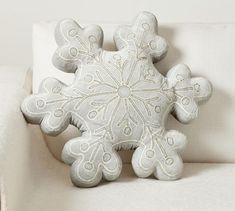 a snowflake pillow sitting on top of a white couch