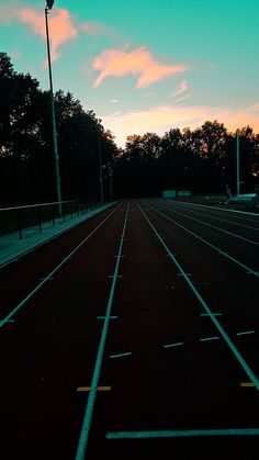 an empty parking lot with trees in the background at sunset or sunrise hours are starting to change