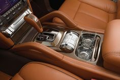 the interior of a luxury car with an automatic gear box and cup holders in it