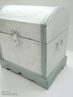 an old white chest sitting on top of a table