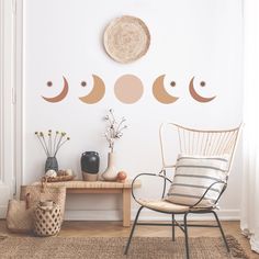 the moon and phases wall decals are on display in this living room, along with a wicker chair