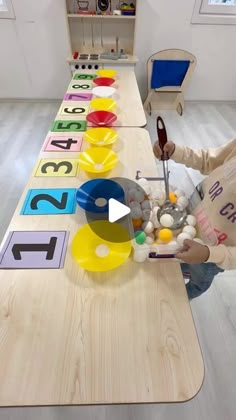 a child is sitting at a table with numbers on it and eggs in the bowl