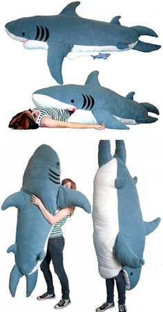 two people are hugging in front of three stuffed shark pillows that look like they're being hugged