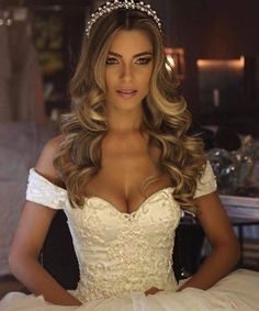 a woman in a wedding dress posing for the camera with her hands on her hips