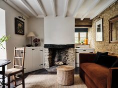 a living room filled with furniture and a fire place next to a wall mounted oven