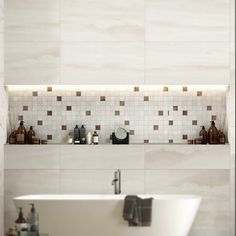 a white bath tub sitting next to a bathroom sink under a mirror and tiled wall