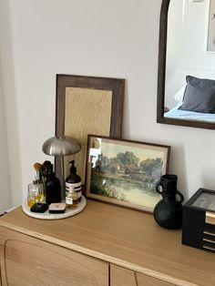 a dresser with some bottles on it and a mirror in the corner above it, along with other items