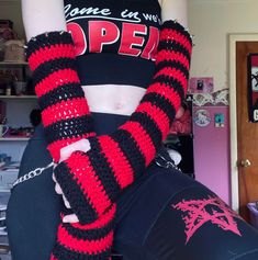 a woman wearing black and red striped arm warmers