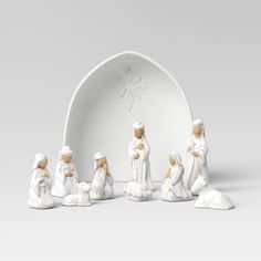 a group of figurines sitting in front of a white arch with a star on it