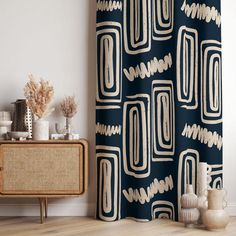 a black and white shower curtain next to a wooden cabinet with vases on it