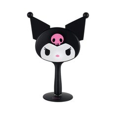 a black and white lamp with a pink skull on it's head, sitting on top of a stand