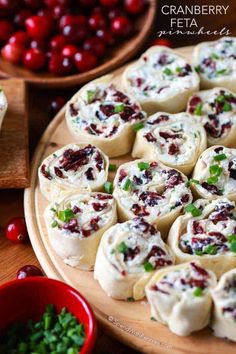 cranberry feta rolls on a wooden platter with red berries in the background