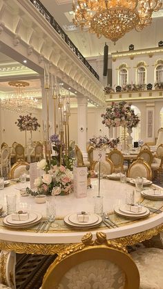 an elaborately decorated dining room with gold chairs and tables set up for a formal function