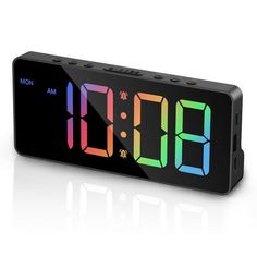 the alarm clock is black and has multicolored numbers on its front side,