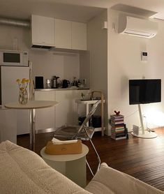 a living room filled with furniture and a flat screen tv on top of a wooden floor