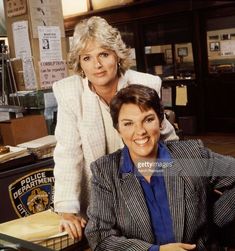 two women sitting at a desk in an office