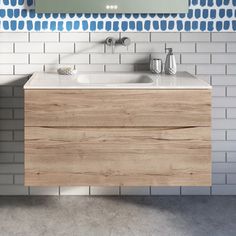 a bathroom with blue and white tiles on the wall, sink and mirror above it