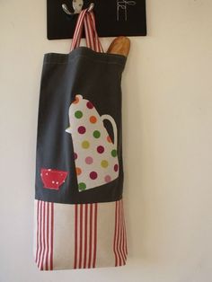 a tote bag hanging on the wall next to a chalk board with a wooden spoon in it