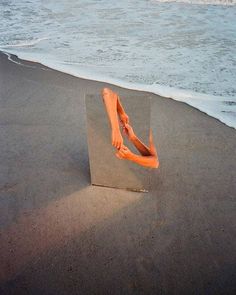 a person's feet sticking out of a box on the beach