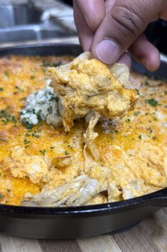 a person dipping some food into a skillet