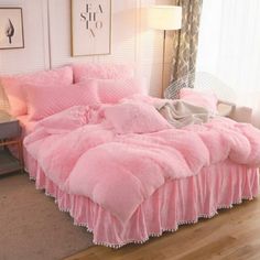 a bed with pink comforters and pillows on it