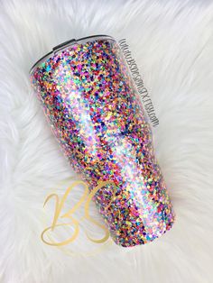 the glitter tumbler is sitting on a white fur