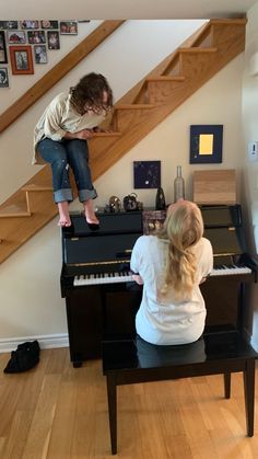 two people are playing piano in the living room