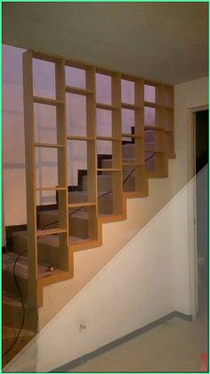 an empty room with some bookshelves on the wall and stairs in front of it