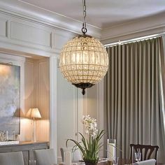 a dining room table with chairs and a chandelier hanging from it's ceiling