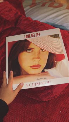 a person holding up a book about lana del rey