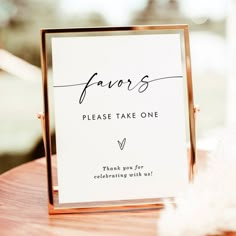 a close up of a table with a sign on it that reads favors please take one