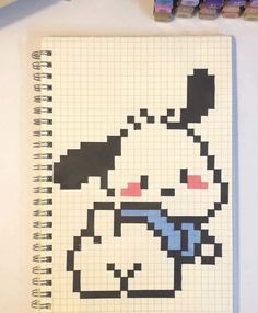 a notebook with an image of a cartoon character drawn on it and colored pencils next to it