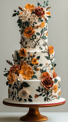 a three tiered cake decorated with flowers and leaves