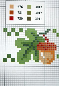 a cross stitch pattern with an orange and green flower on the left side, which is colored in different shades