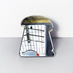 a mirror that is sitting on top of a table in front of a white wall