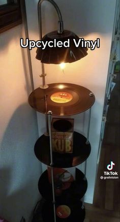 a lamp that is sitting on top of a shelf in a room with the words upcycled vinyl