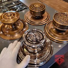 a person is touching the knobs on a stove top with other kitchen appliances in the background