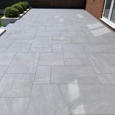 an outdoor patio with grey tiles and plants