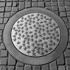 a manhole cover in the middle of a brick road