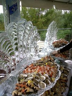 several platters of food are displayed on the outside table for people to enjoy it