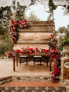 a wooden bench covered in flowers and greenery