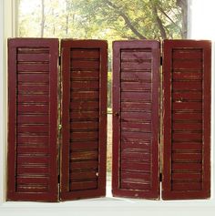 three red shutters open in front of a window