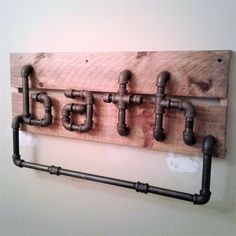 a wooden sign with pipes attached to it and the word eat spelled in black letters