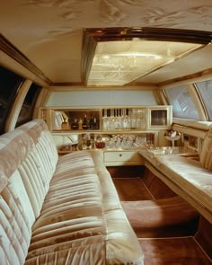 the inside of a car with couches, cabinets and wine glasses on it's shelves