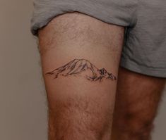 a man with a mountain tattoo on his leg