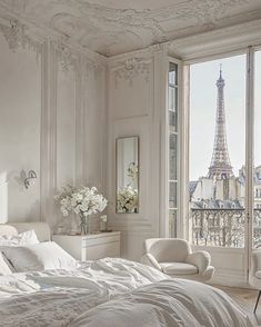 a bedroom with a view of the eiffel tower from it's windows