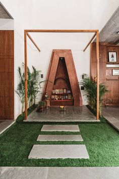 an indoor area with grass and wooden structures