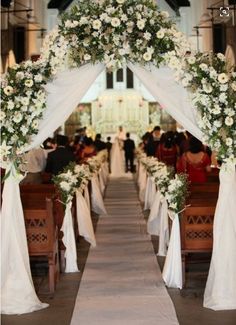 the wedding arch is decorated with white flowers