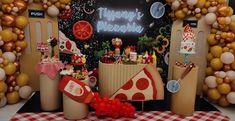 there is a pizza themed party set up with balloons and streamers on the wall