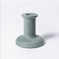 a gray vase sitting on top of a white table